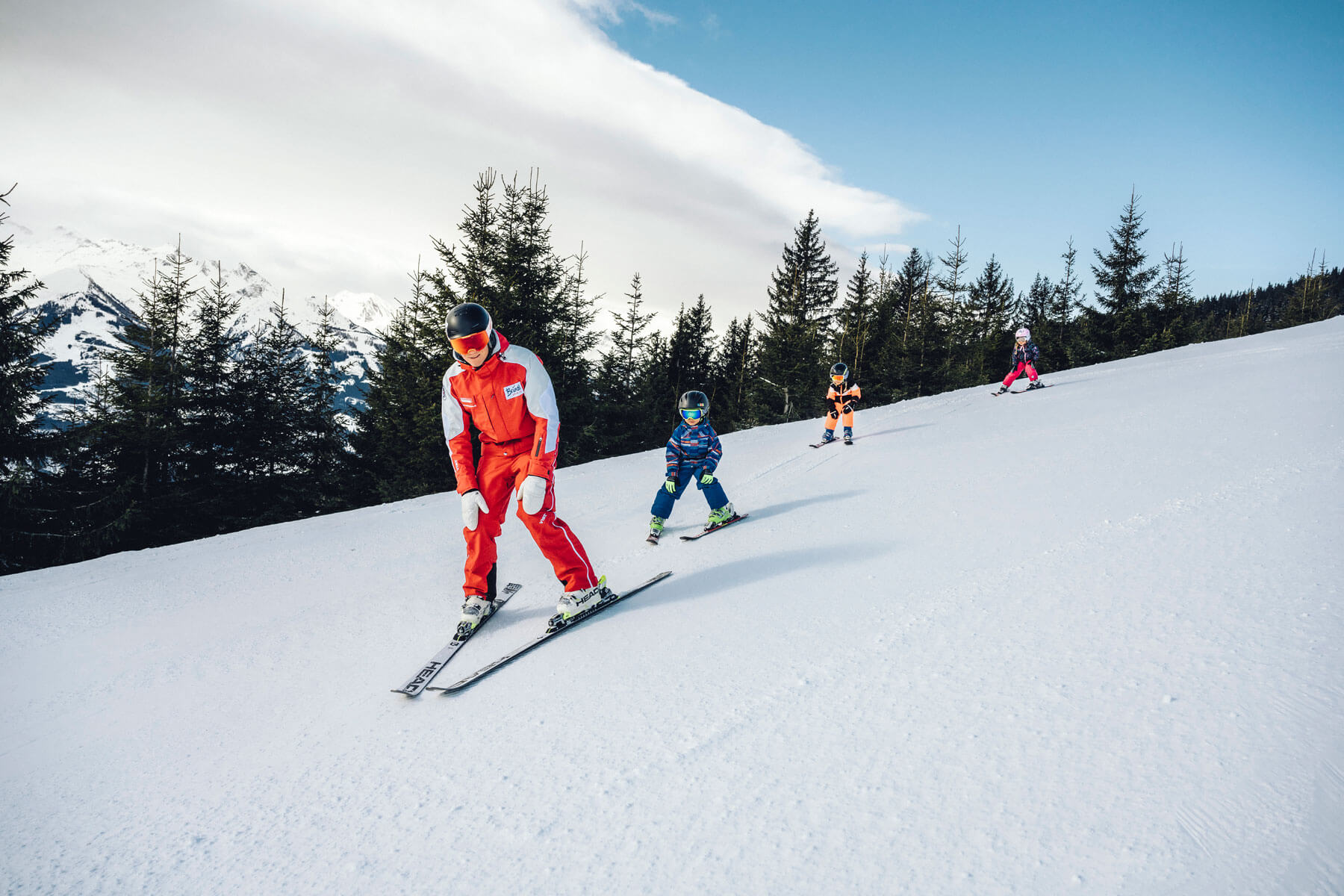 Skilehrer beim Skifahren mit Kids